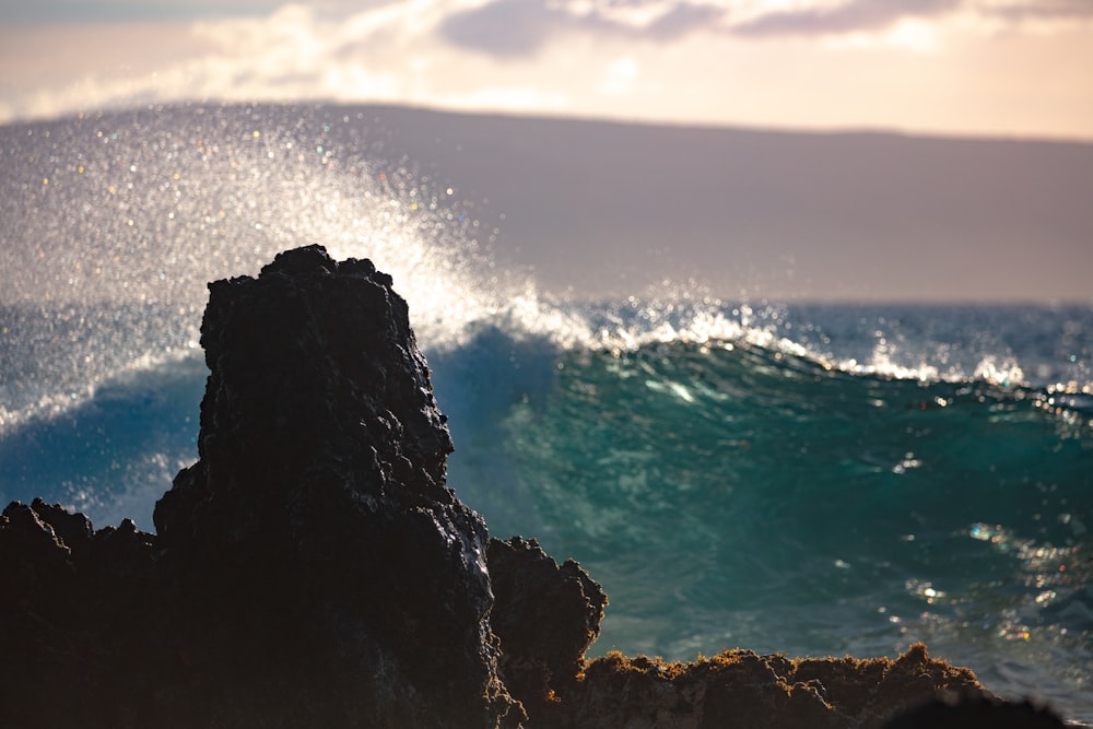 rock formation front of sea waves at daytime