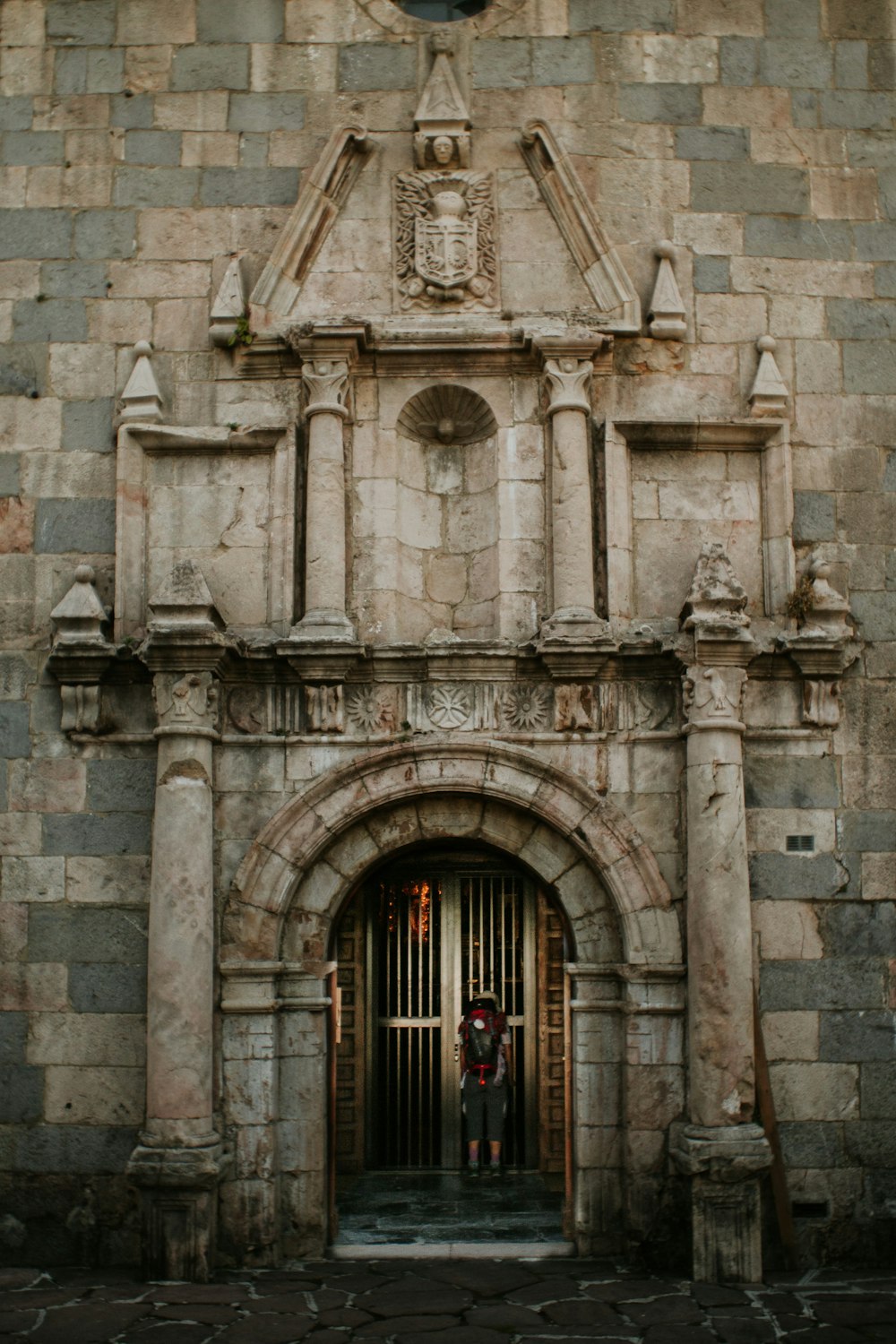 man standing beside building door