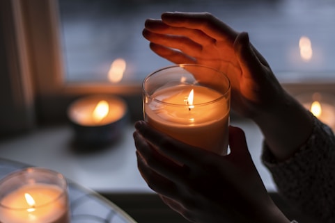 A woman gently lighting a candle, symbolizing hope and solidarity during the event.