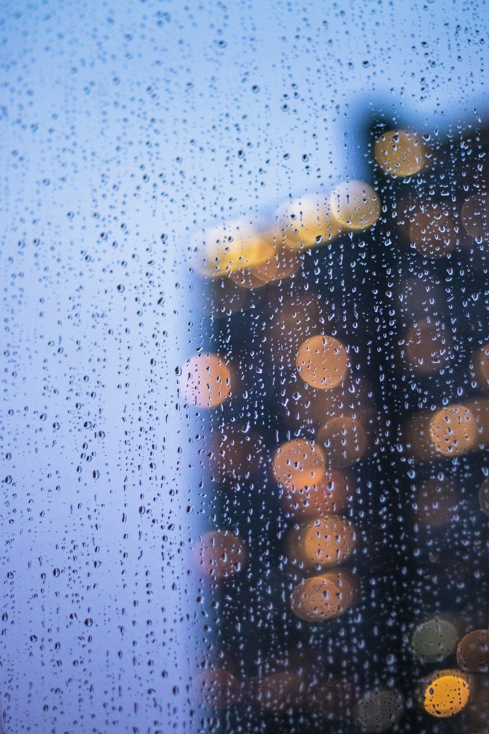 gotas de chuva em uma janela com um edifício ao fundo