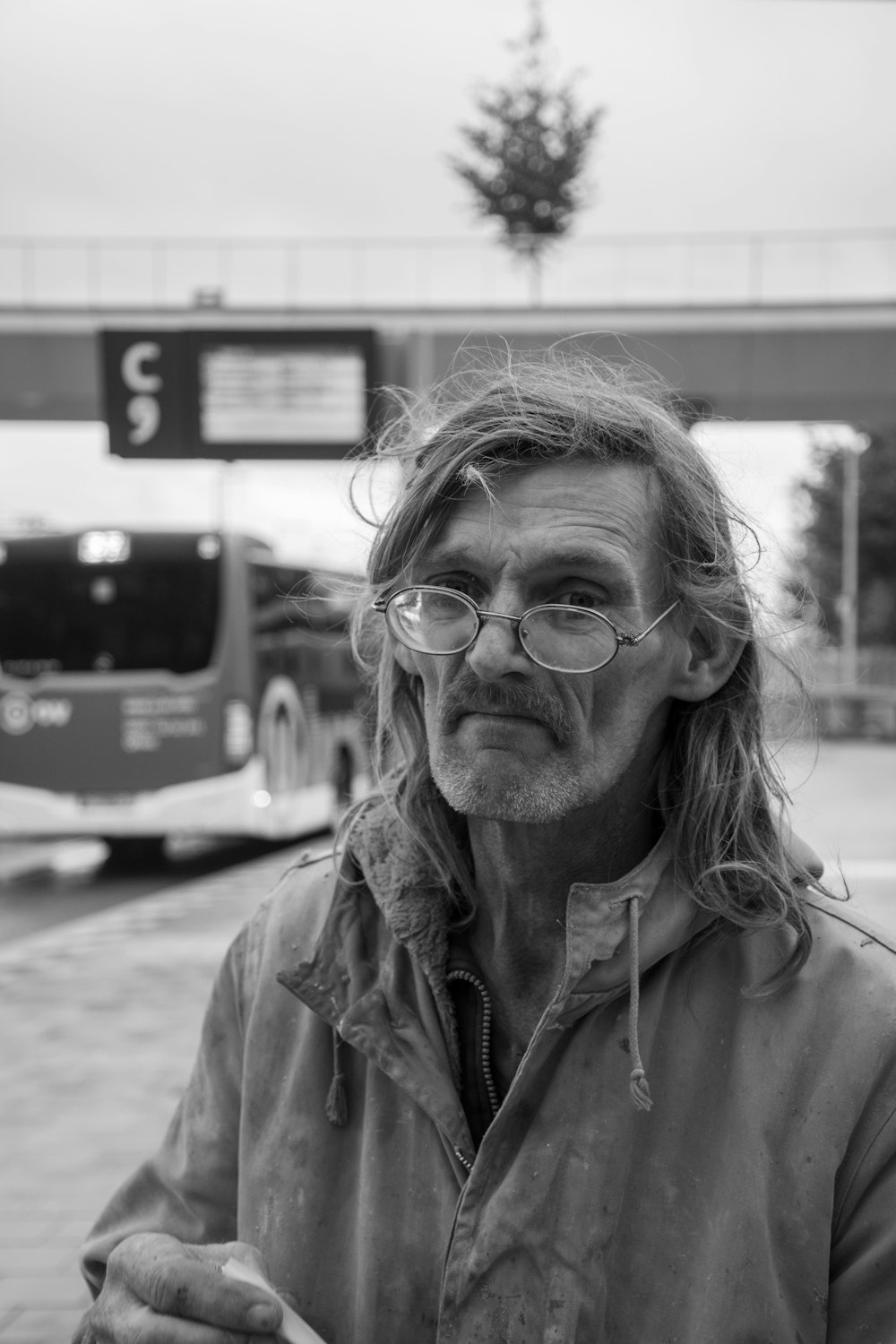 gray scale photo of man wearing eyeglasses and jacket