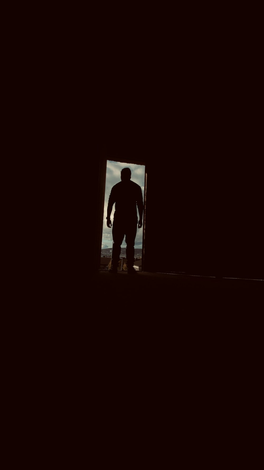 silhouette of man standing in door