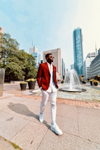 A stylish man wearing a sharp red jacket from Apex Trading, standing confidently against a city backdrop.