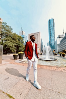 A model wearing a sharp red blazer walking confidently in an urban setting.