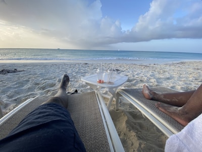 Waitstaff serving drinks to relaxed guests lounging in beach chairs.