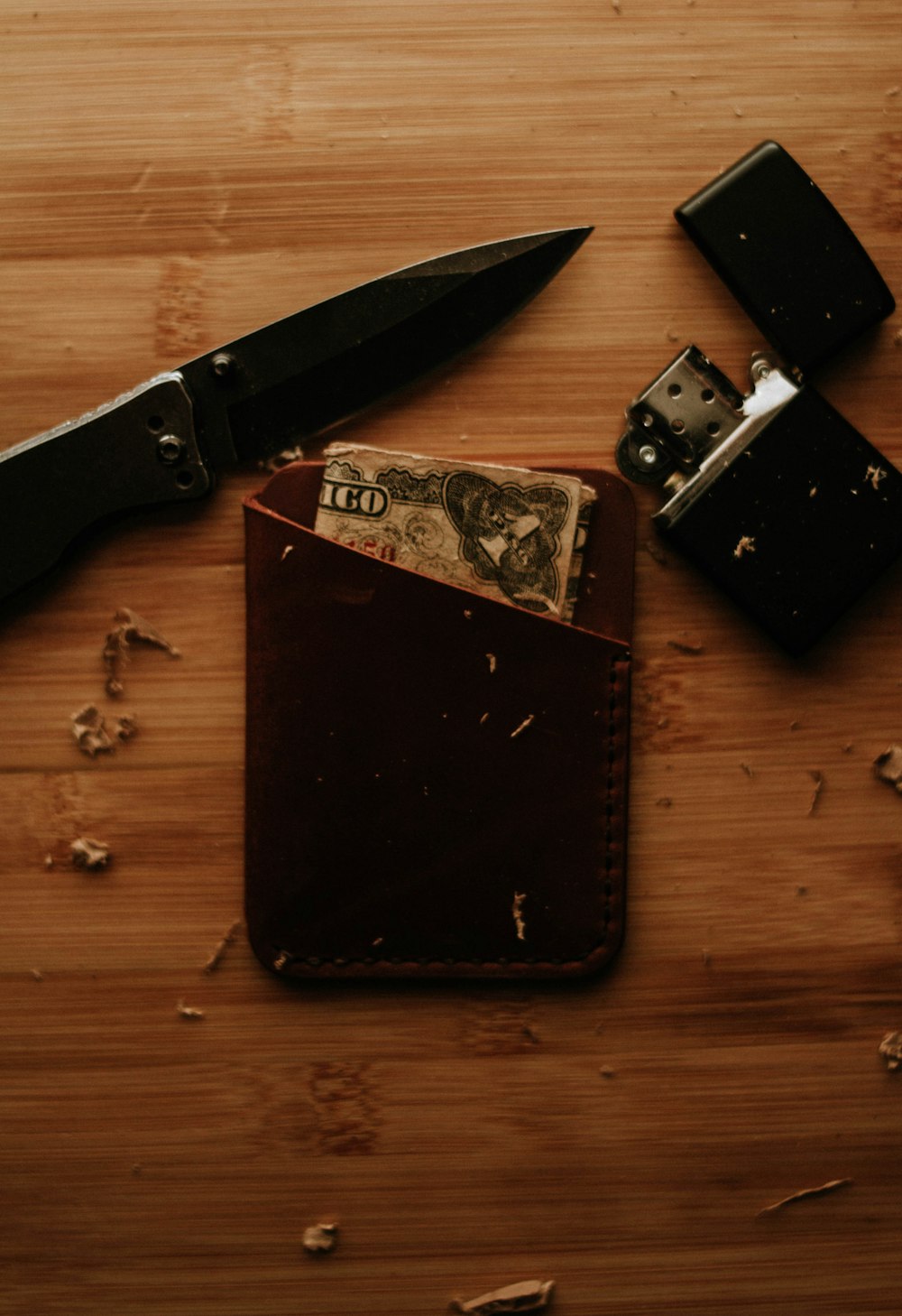 brown leather wallet and black flip lighter