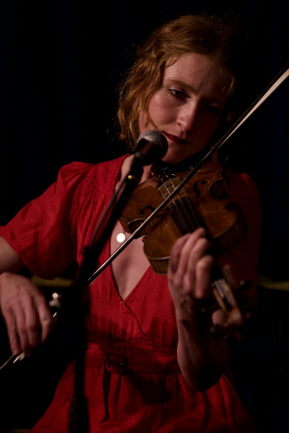woman playing violin in front of microphone