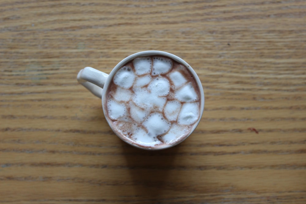 mug with beverage and marshmallows on wooden surface
