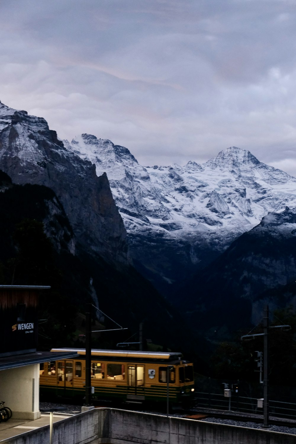 brown train passing near snow-capped mountain