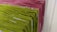 Racks of pasta are hanging side by side, with varying colors indicating different types or flavors. The pasta is neatly arranged and appears to be freshly made, showcasing green and pink hues.