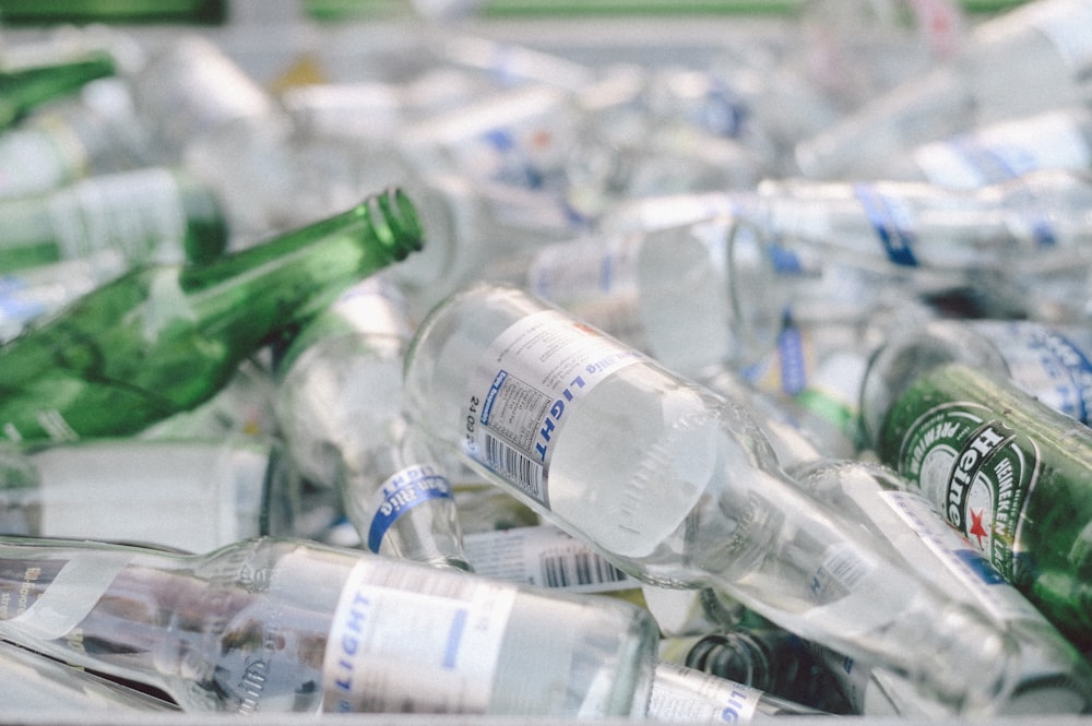 pile of empty green and clear glass bottle lot