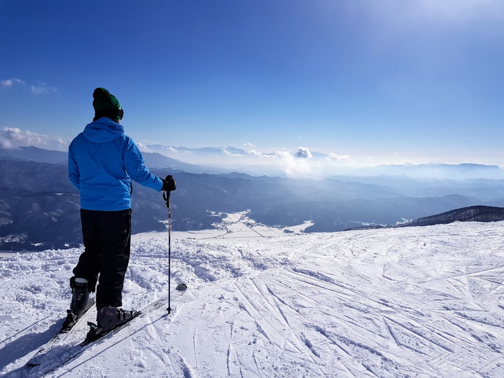 man standing on snow under blue sky