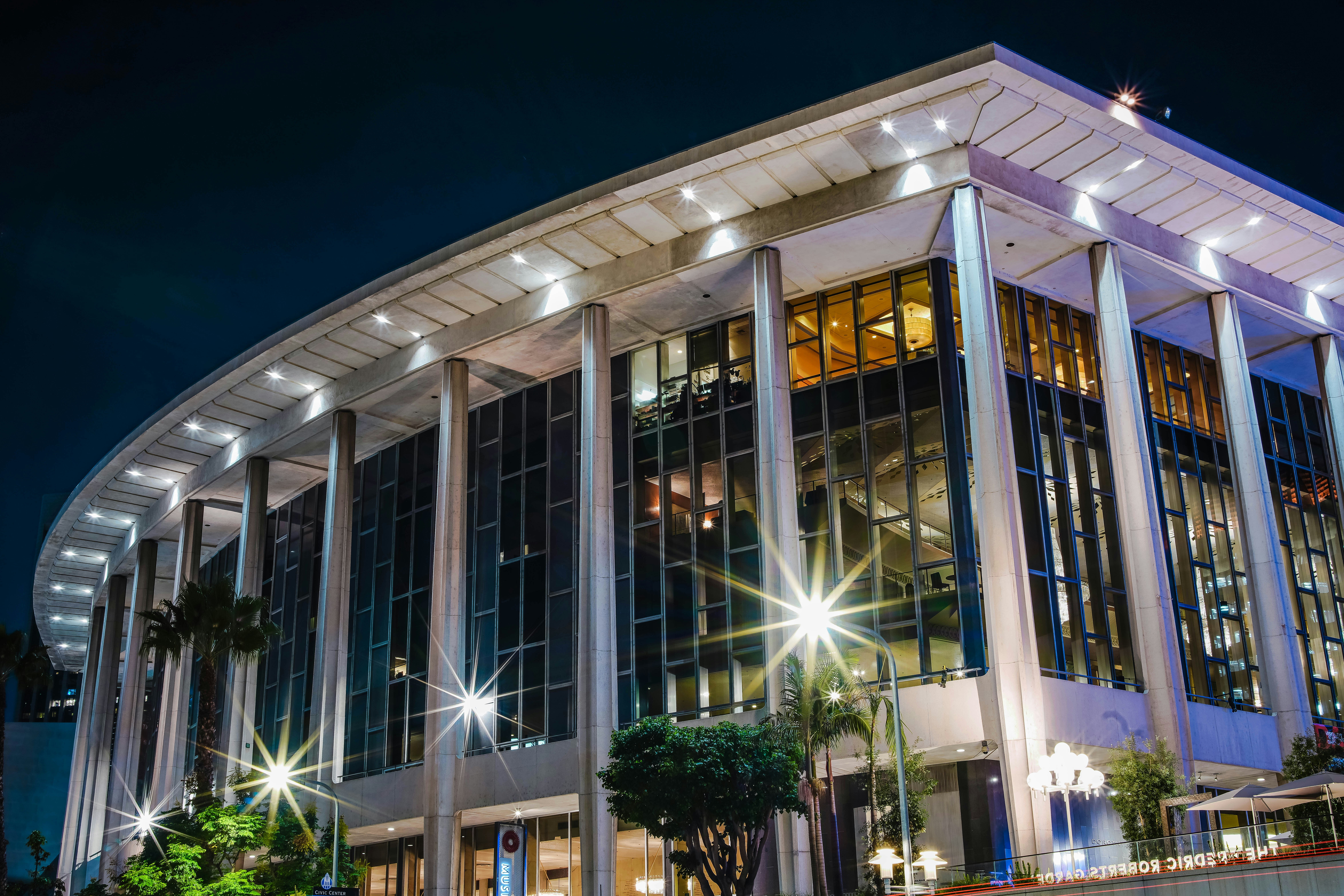 low-angle photography of gray and black concrete building under blue sky
