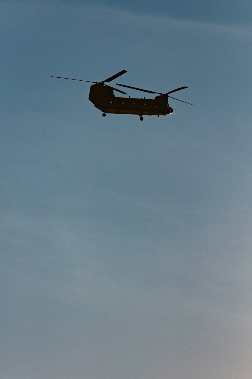 brown and black helicopter flying in the sky
