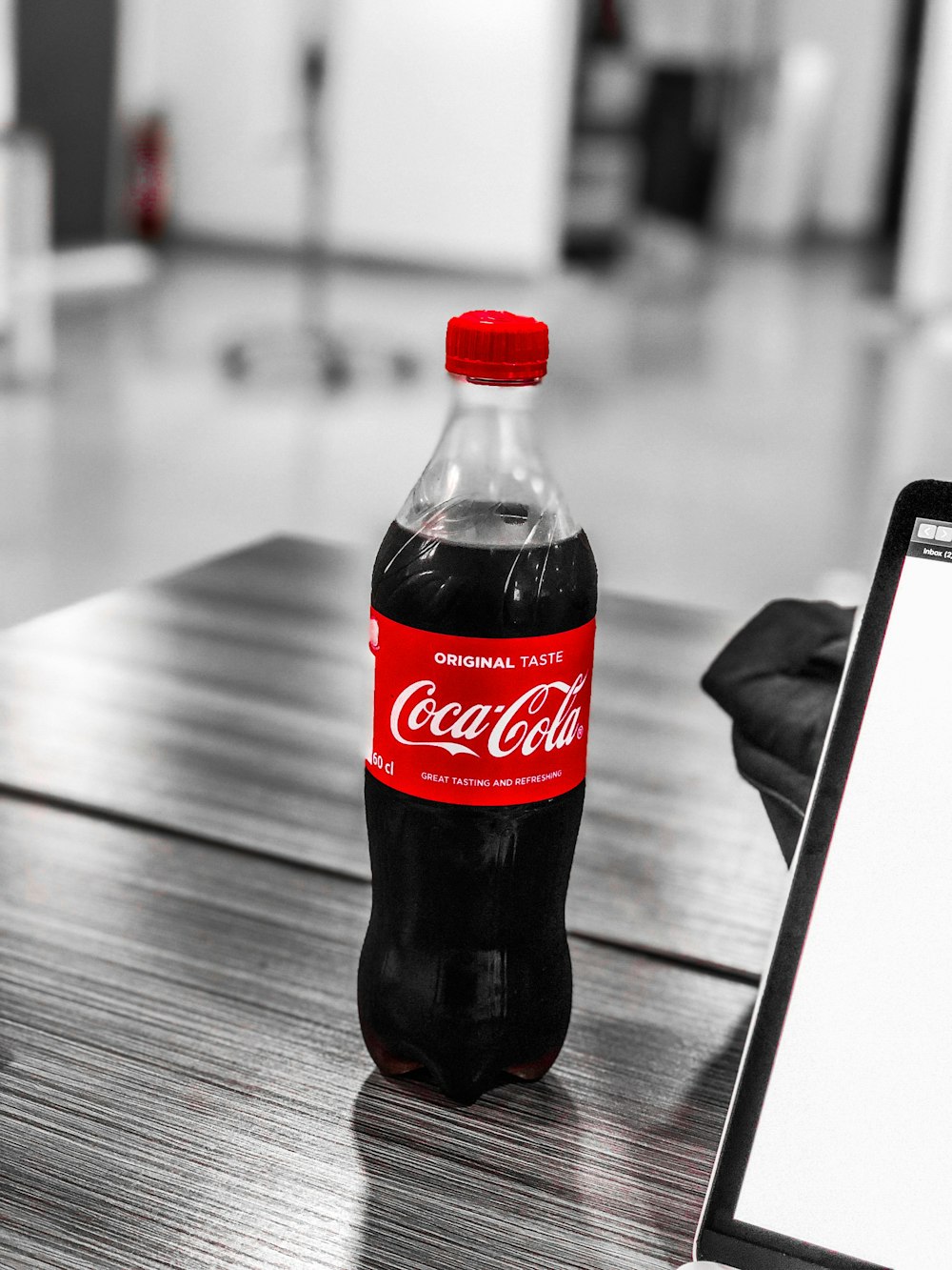 Botella de plástico de Coca-Cola sobre mesa de madera