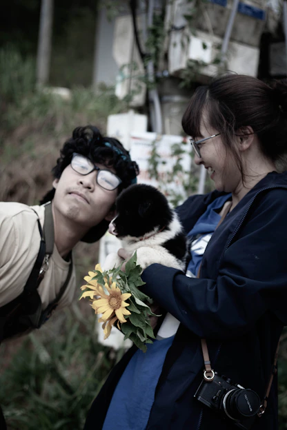 A candid photo of a joyful couple with their dog during an outdoor wedding in Münsterland.