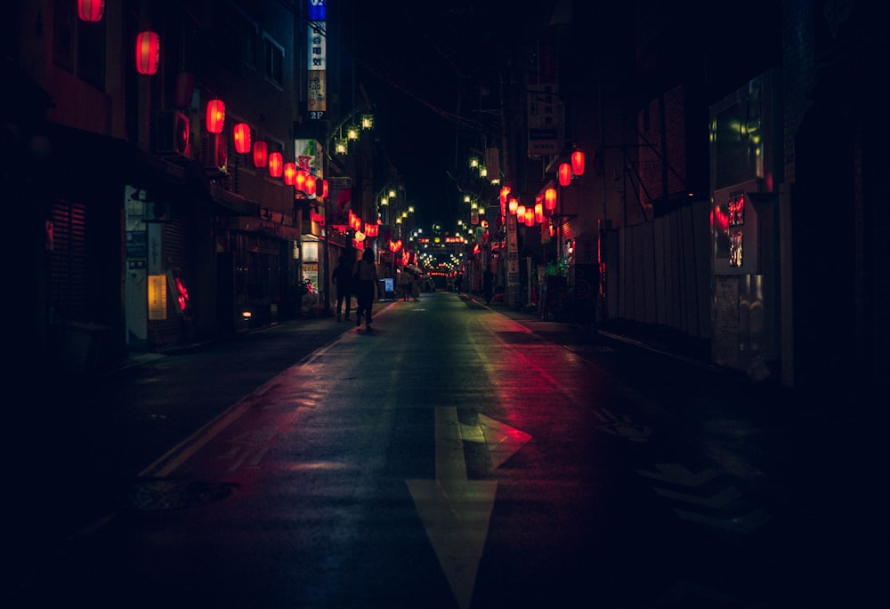 silhouette of person standing beside road during nighttime