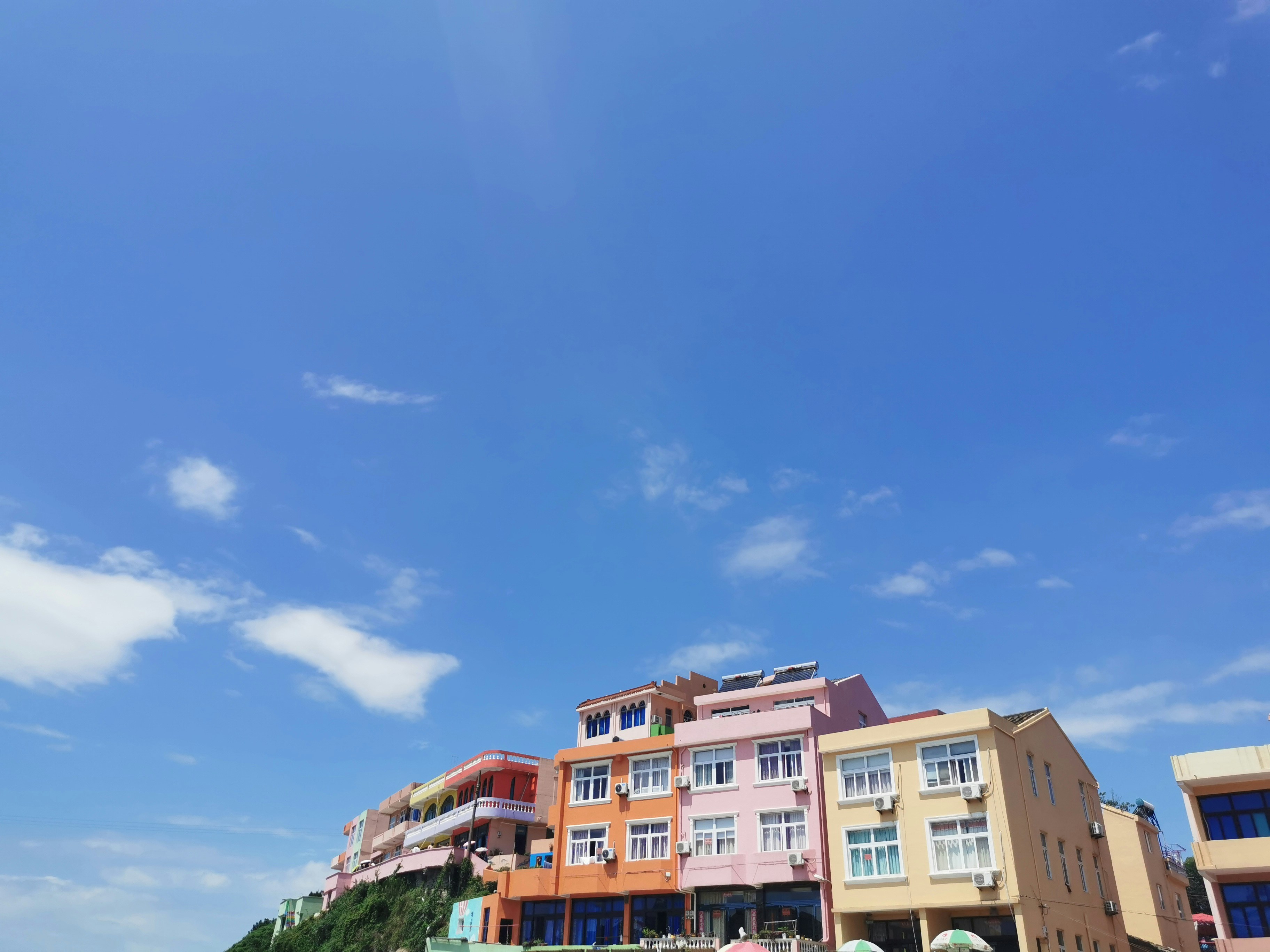 A modern oceanfront home with large, strong windows under a dramatic, cloudy sky, symbolizing resilience in the face of nature.