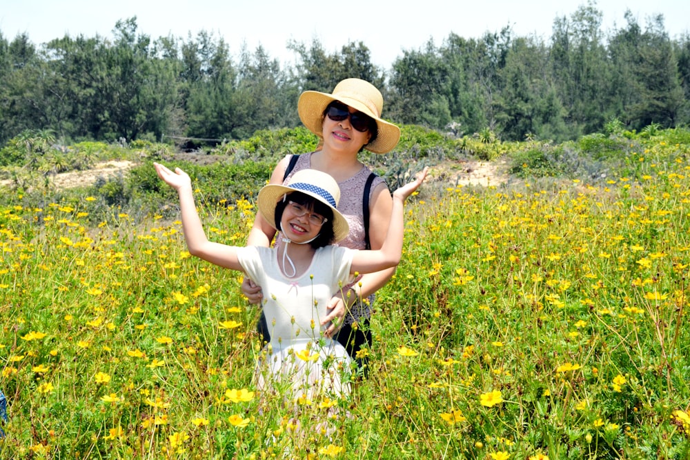 two person standing on field of flowers