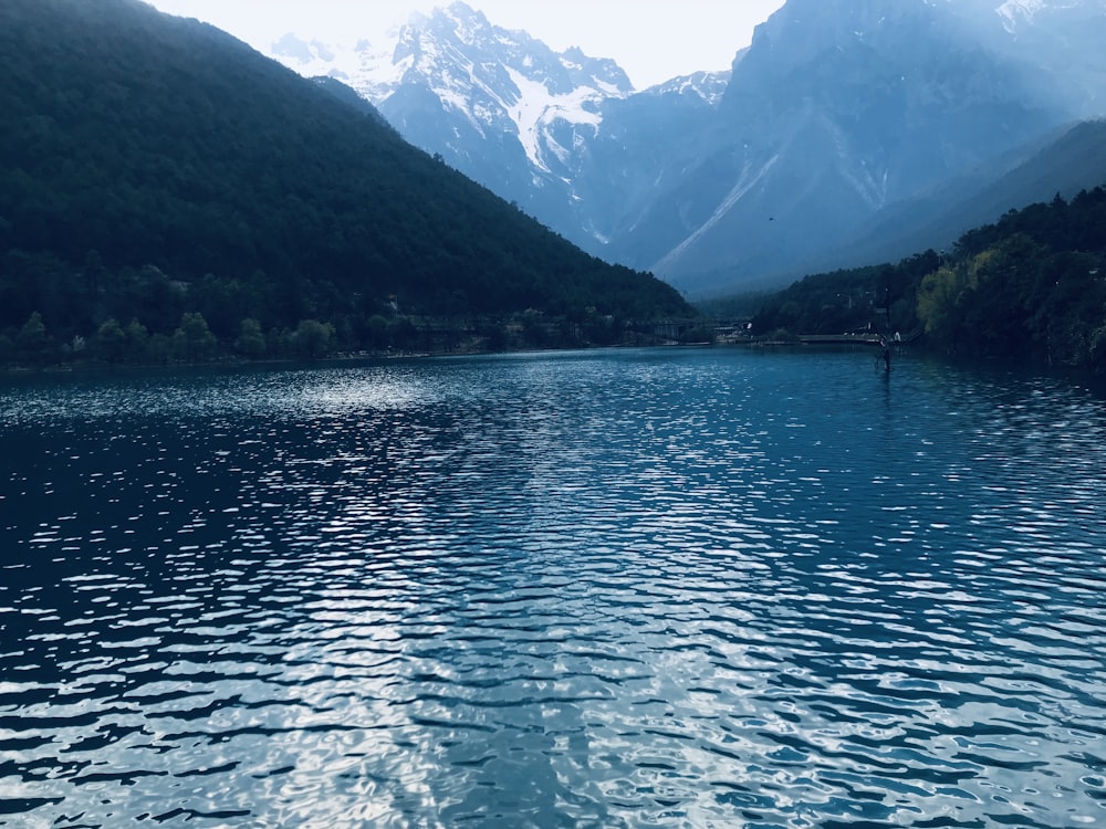 calm body of water near mountains
