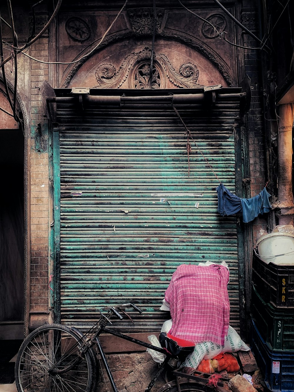 black commuter bike parked beside shutter door