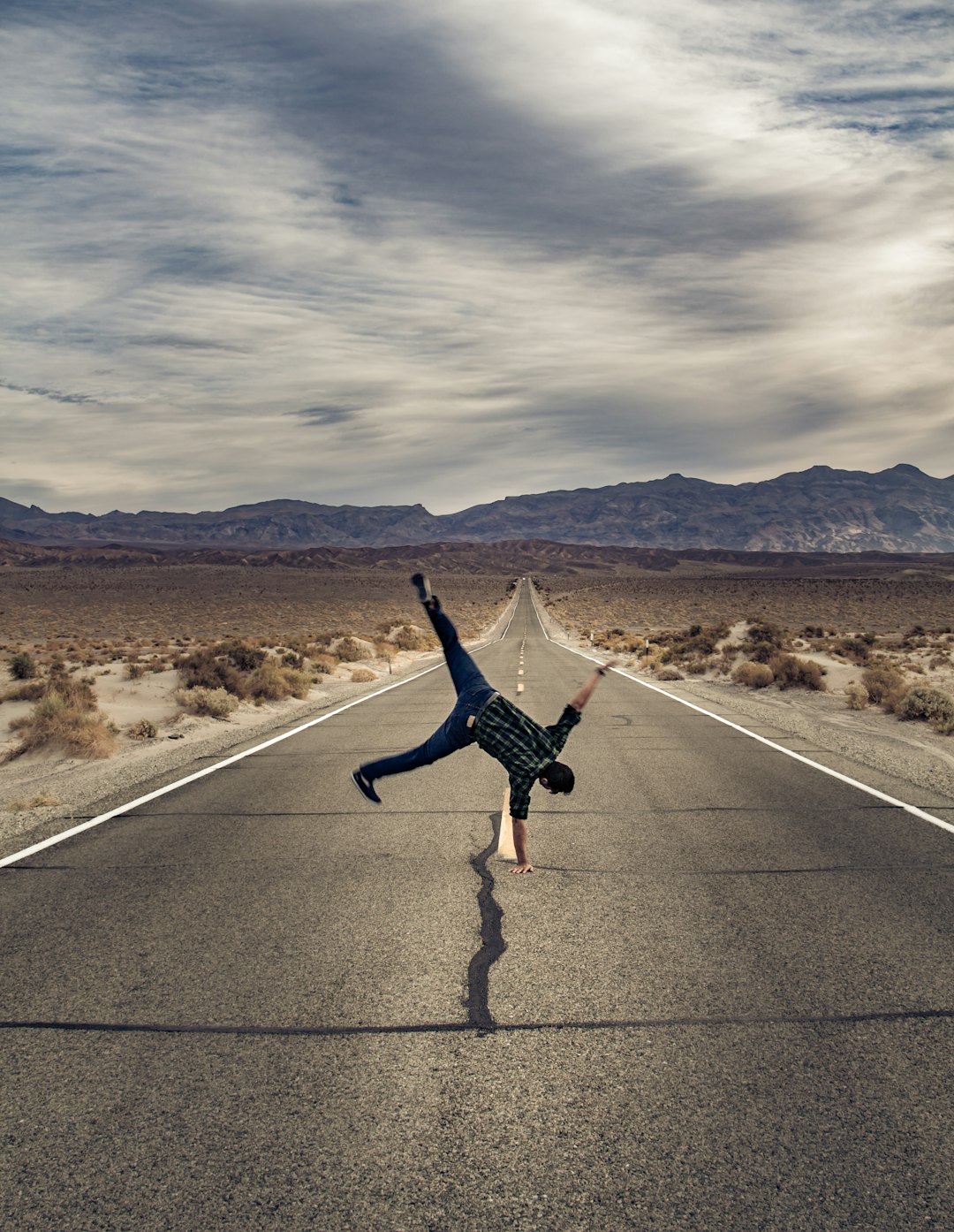 man standing with his right arm on road during daytime