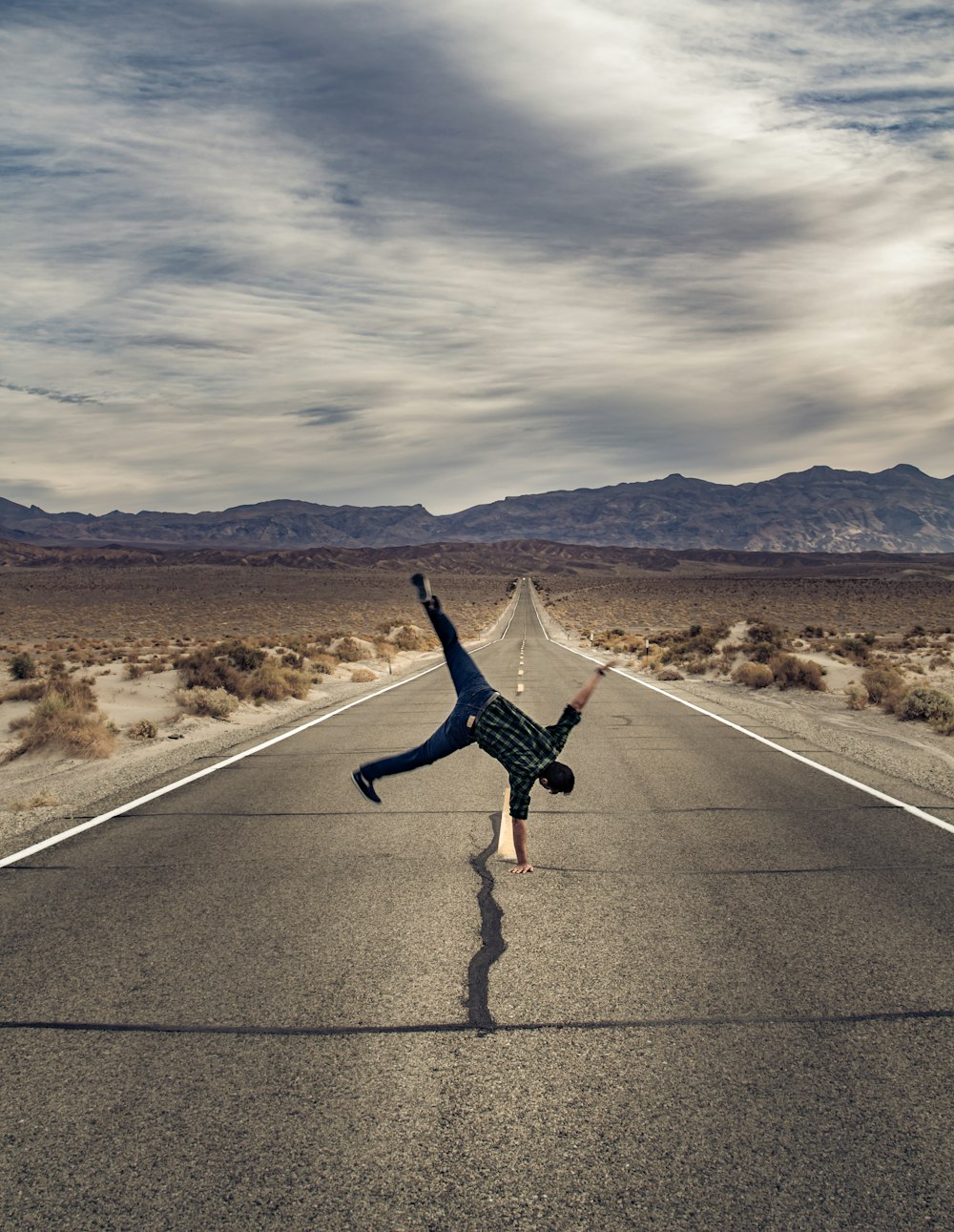 man standing with his right arm on road during daytime