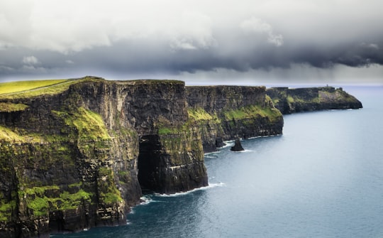 sea and cliff during daytime in Cliffs of Moher Ireland