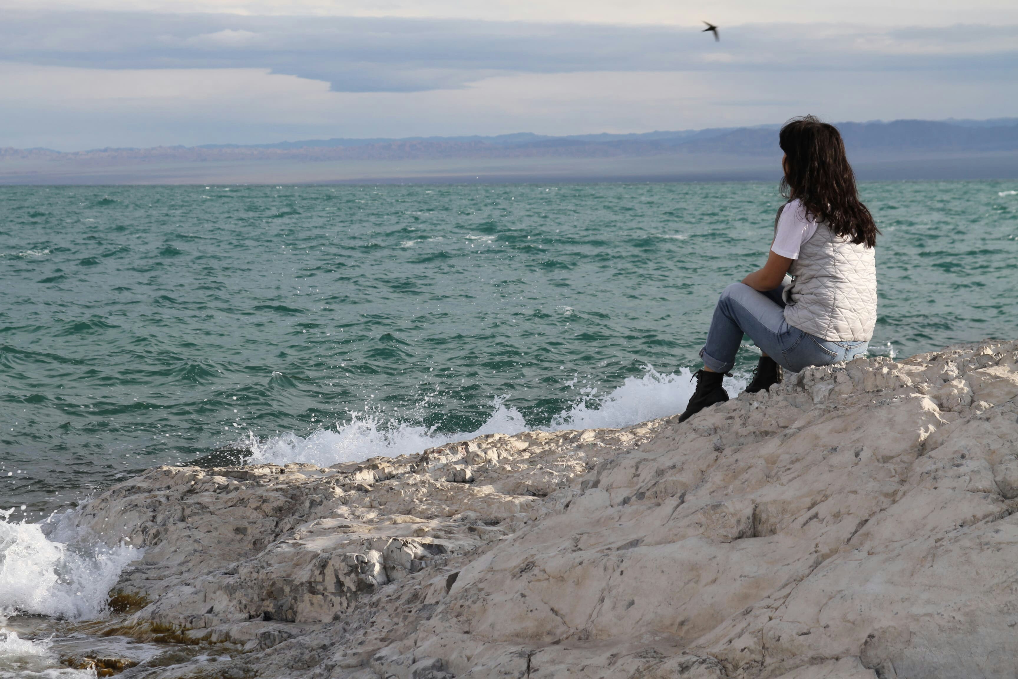 woman sitting on rocky mountain