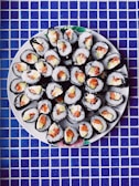 Colorful sushi rolls arranged neatly on a wooden platter.