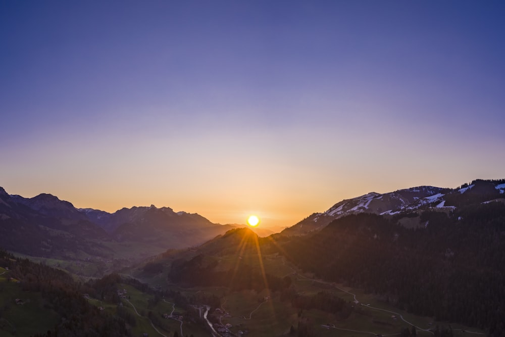 sun rays coming through mountain during daytime