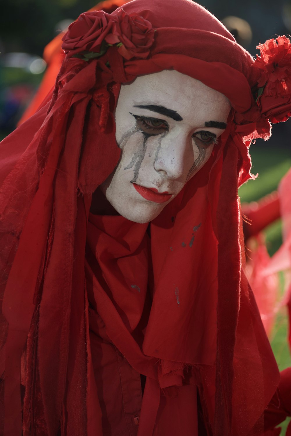 person in red dress with white face makeup
