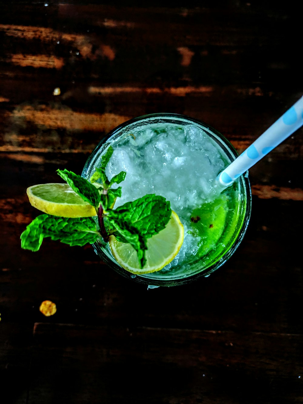 clear liquid in cup with slices of lemon and green gerb