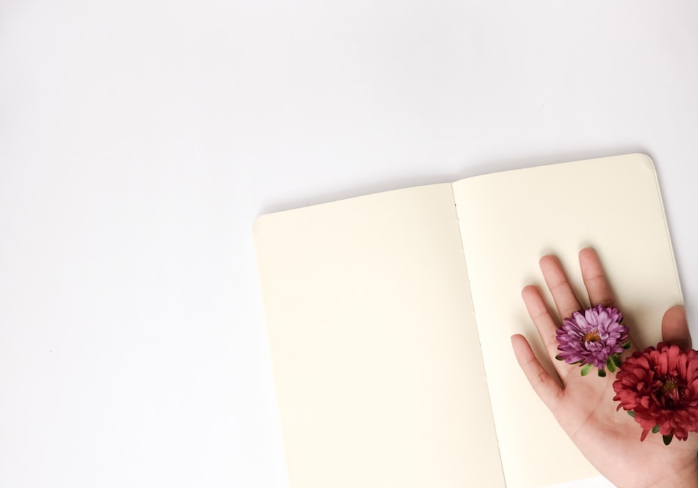 person holding flowers on open book page