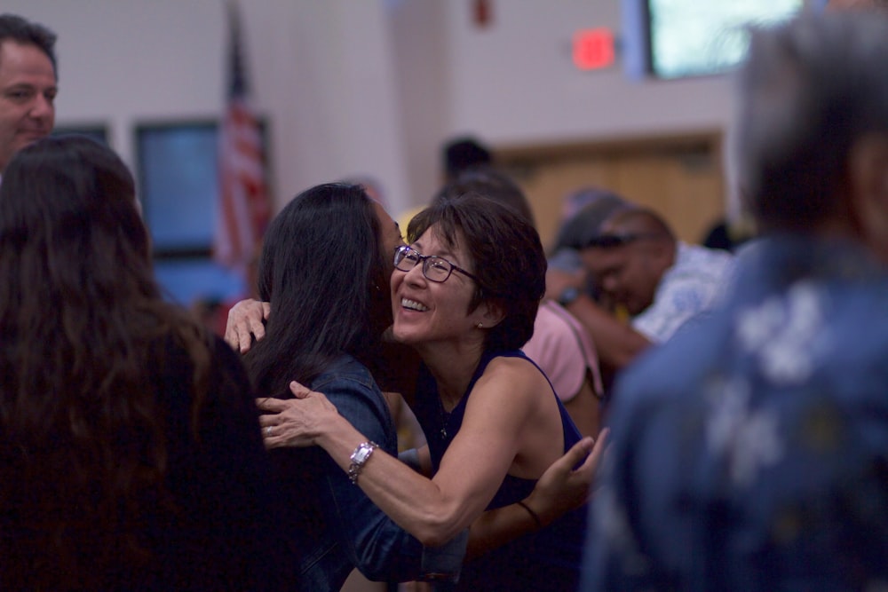 selective focus photography of two women hugging