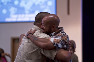 two man hugging on focus photography