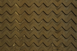 Close-up of textured safety floor mats in a busy factory aisle.