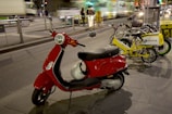 A sleek electric scooter parked on a city street at sunset.