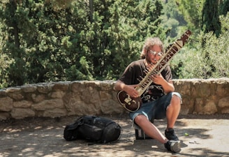 man holding string instrument during daytime