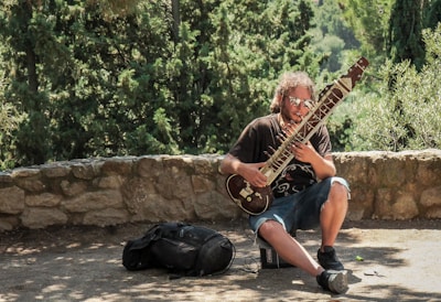 man holding string instrument during daytime