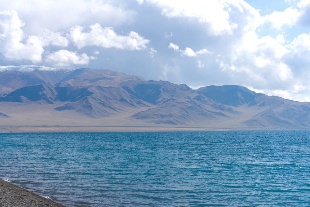 brown mountains near body of water