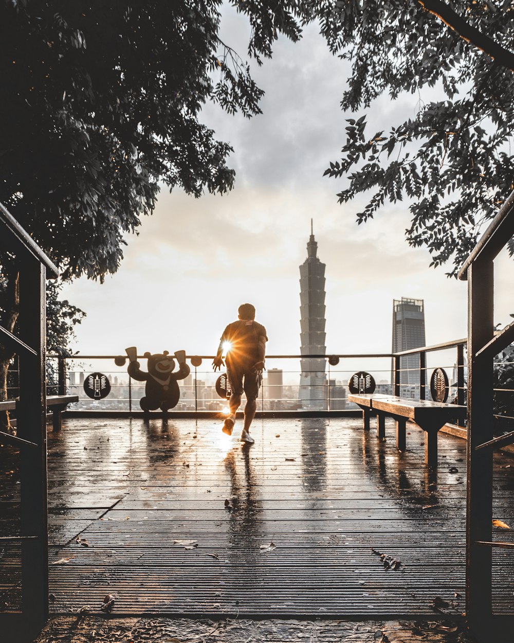 man standing beside wooden bench across gray tower