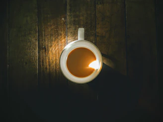 A stylish, glossy mug sitting on a wooden table with soft natural light.