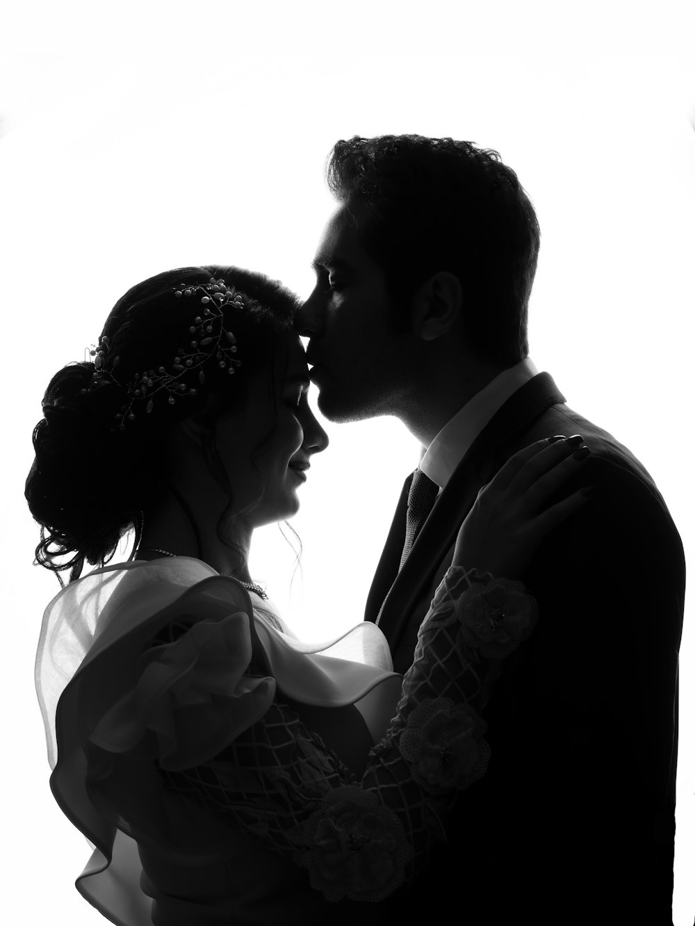 silhouette of man kissing forehead of woman
