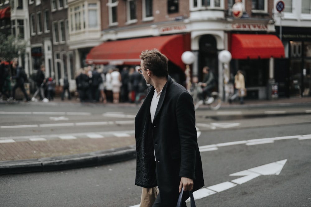 man in a black coat by a street