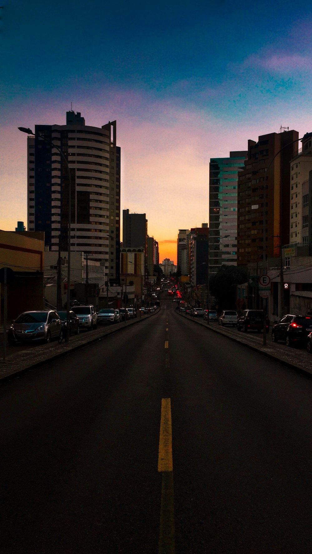 cars parked on road side during sunset