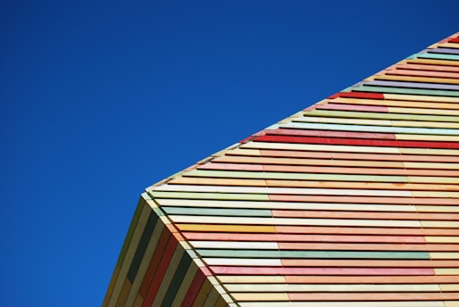 Exterior of a building showing a freshly painted colorful facade under clear sky.
