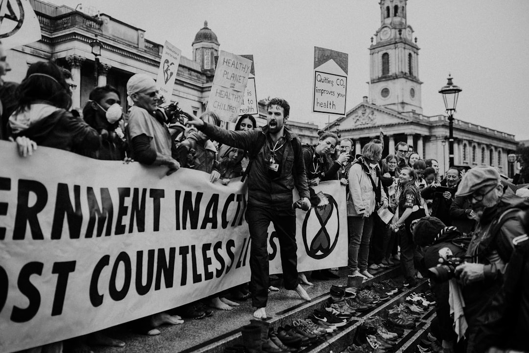 grayscale photography group of person protesting outdoors