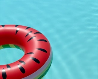 red and green lifebuoy on swimming pool