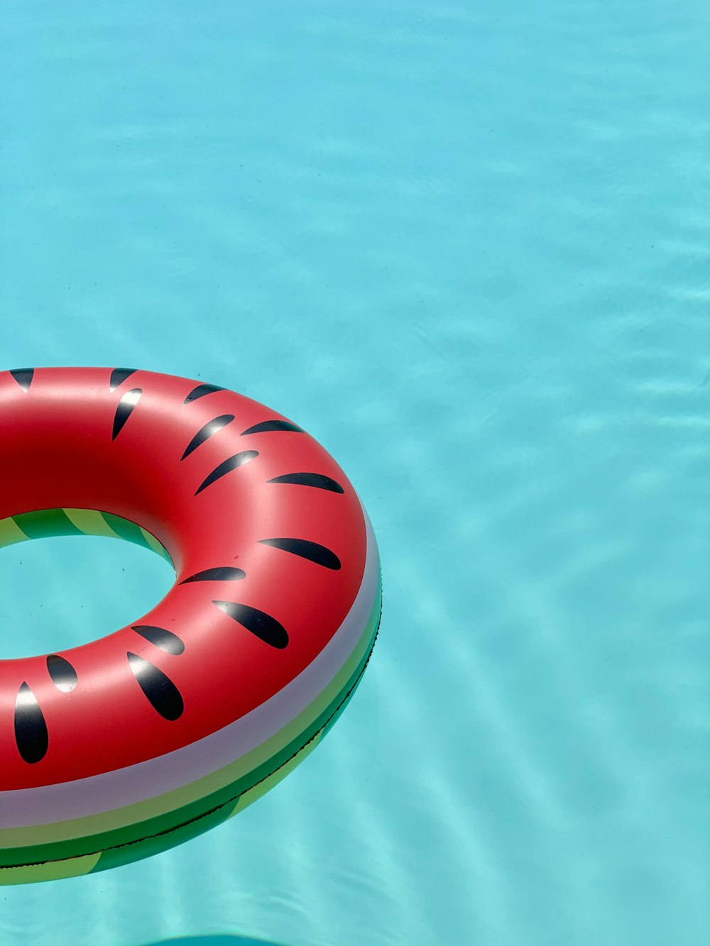 red and green lifebuoy on swimming pool